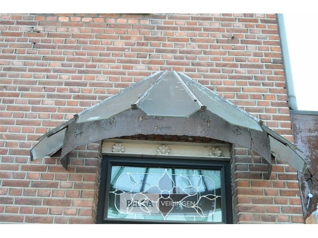1 inkom afdakje gemaakt van verroest metaal en heeft een gebogen structuur - afbeelding 1 van  3