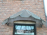 1 inkom afdakje gemaakt van verroest metaal en heeft een gebogen structuur - afbeelding 1 van  3