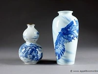 Chine - xxe siècle deux vases. l'un en double gourde, l'autre fuselé. porcelaine émaillée en camaïeu de bleu d'un aigle et d'un paysage avec pavillon. marque sigillaire. - afbeelding 1 van  2