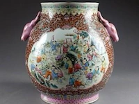 De style qianlong. vase “hu“ accosté par deux têtes de daim. fond rouge rubis à motifs de rinceaux, ru-yi et chauves-souris, décoré de larges vignettes découpées animées de nombreux enfants. porcelaine de chine. xxe siècle. - afbeelding 1 van  1