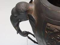 Grote art déco vaas in africanistische stijl. handgrepen elk in de vorm van een olifantenkop waarvan de slurf een ring vasthoudt. decoratie in reliëf met een olifant aangevallen door roofdieren. verzilverd metaal. hoogte: 35 cm - afbeelding 2 van  3
