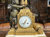 Mantelklok en bronzen kandelaars