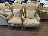 2 klassieke fauteuils met houten frame en lichte beige bekleding (vertoont gebruikssporen)
