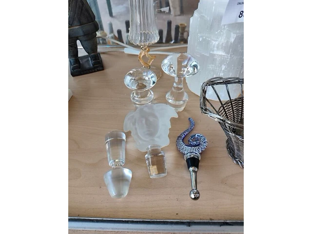 2 zuilkandelaars met acryl middenstuk, decoratief beeldje van een chinese terracotta krijger, 6 glazen flessenstoppen, karafstop medusa hoofd versace, glazen geribbelde vaas op voet, 3 decoratieve stenen eieren, verzilverde draadmand met handvat, 2 glazen - afbeelding 13 van  13