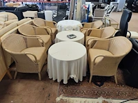 6 imitatie rotan zetels, 2 ronde houten bijzettafels met tafelkleed, 1 ronde donkerhouten bijzettafel met 1 lade op centrale voet