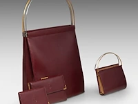 A cartier burgundy 'trinity' top handle bag, wallet and two 'must de cartier' wallets