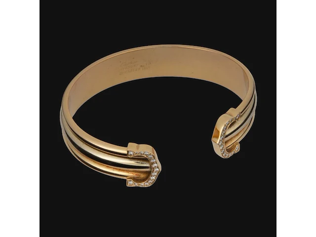 A cartier ressort 'double c' bracelet in 18ct yellow gold and diamonds, weight: 26,9 g (+) - afbeelding 1 van  8