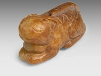 A chinese carved archaistic jade pendant of a lion, l 4,8 cm