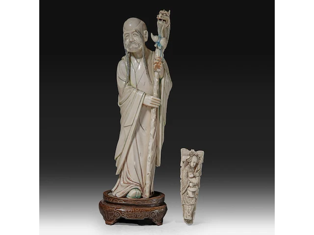 A chinese ivory sculpture of a sage leaning on his kirin-shaped staff, with a small double gourd hanging from it, added a ditto sculpture of a lady laying down with a child, late qing dynasty (1644-1912), total h 30 cm - - afbeelding 1 van  7