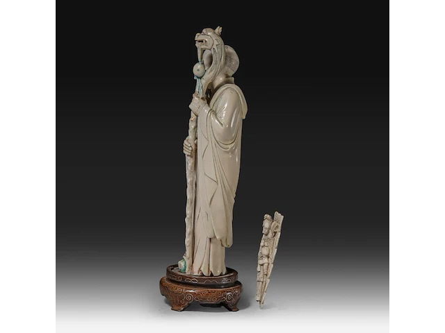 A chinese ivory sculpture of a sage leaning on his kirin-shaped staff, with a small double gourd hanging from it, added a ditto sculpture of a lady laying down with a child, late qing dynasty (1644-1912), total h 30 cm - - afbeelding 3 van  7