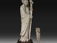 A chinese ivory sculpture of a sage leaning on his kirin-shaped staff, with a small double gourd hanging from it, added a ditto sculpture of a lady laying down with a child, late qing dynasty (1644-1912), total h 30 cm - - afbeelding 5 van  7