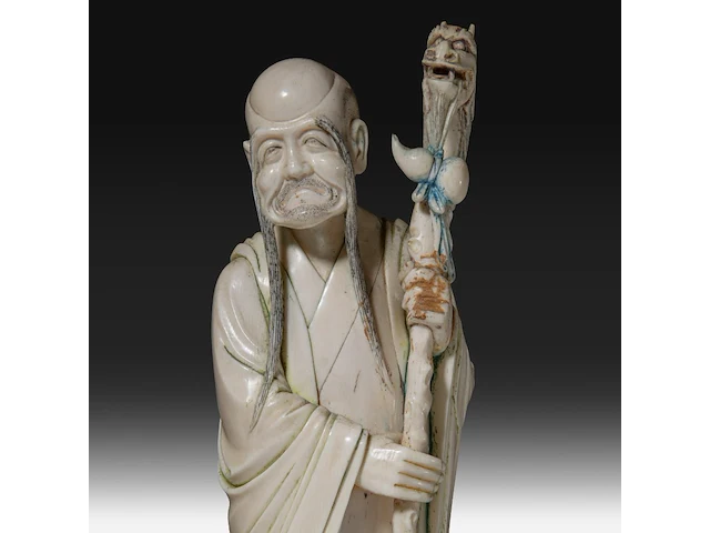 A chinese ivory sculpture of a sage leaning on his kirin-shaped staff, with a small double gourd hanging from it, added a ditto sculpture of a lady laying down with a child, late qing dynasty (1644-1912), total h 30 cm - - afbeelding 6 van  7