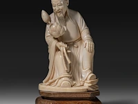A chinese ivory sculpture of a scholar holding lotus buds, late qing dynasty (1850-1912), total h 18 cm - ivory h 15 cm - ivory weight 524g (+)