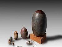 A collection of tantric shiva lingams and one silver lingam (narmada bana) hanger, india, h 34 cm (tallest)