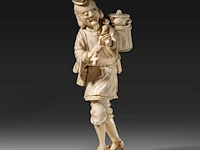 A fine japanese ivory okimono of a man carrying a stick and basket, signed, meiji period (1868-1912), h 22 cm - 456g (+)