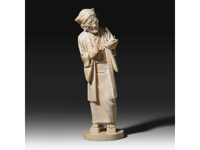 A fine japanese ivory okimono of a man with glasses examining a nest of birds in his hand, signed, tokyo school, meiji period (1868-1912), h 20,5 cm (+) - afbeelding 1 van  9