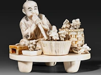 A fine japanese ivory okimono of a man working abalone shells, meiji period (1868-1912), h 10,5 cm - w 11,5 cm - 409g (+)
