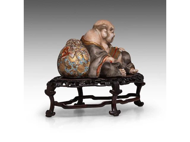 A finely painted japanese polychrome porcelain figure of hotei leaning against the bag of good fortune, l 22 cm - figure h 14,5 cm - total h 22,5 cm - afbeelding 6 van  8
