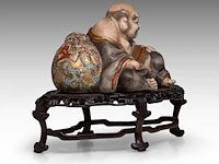 A finely painted japanese polychrome porcelain figure of hotei leaning against the bag of good fortune, l 22 cm - figure h 14,5 cm - total h 22,5 cm - afbeelding 6 van  8