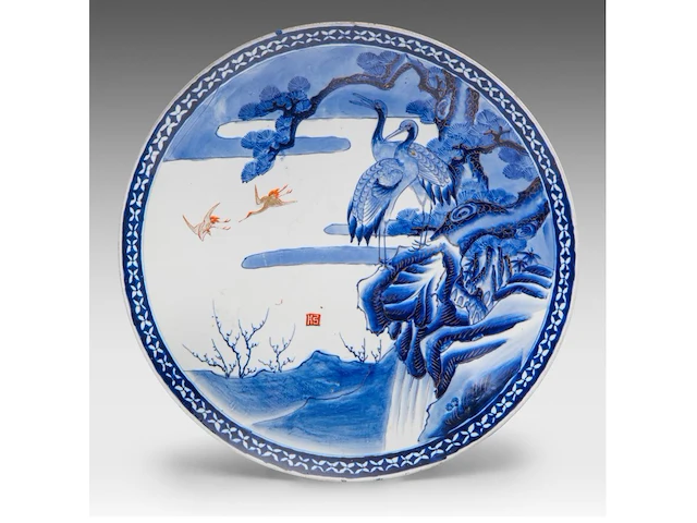 A japanese arita ware dish with a landscape of cranes and a waterfall, marked, 19thc, ø 46 cm - afbeelding 1 van  2