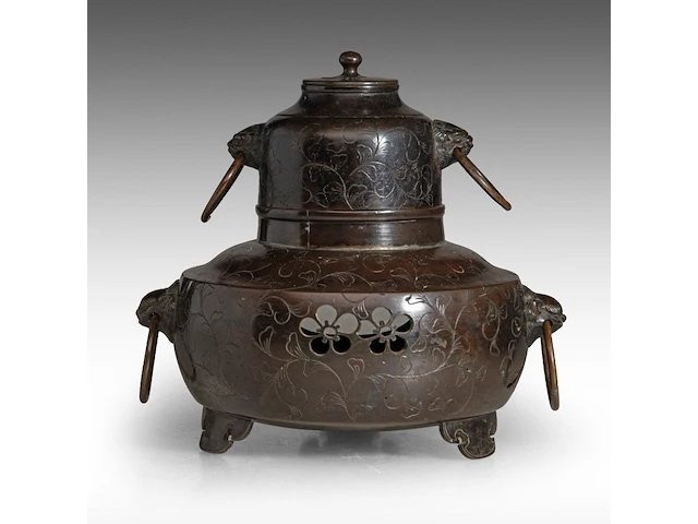 A japanese bronze chagama-shaped koro or incense burner, with floral engraved motifs and shishi heads with rings in their mouths for handles, meiji period (1868-1912), h 19 cm - afbeelding 1 van  7