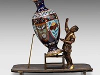 A japanese bronze okimono of a man working on a giant cloisonné vase, meiji period (1868-1912), h 25 cm