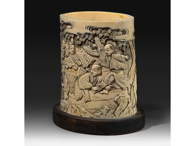 A japanese ivory brushpot, carved with figures in a landscape playing a game, meiji period (1868-1912), total h 14 cm - w 13 cm - d 10 cm (+) - afbeelding 2 van  7