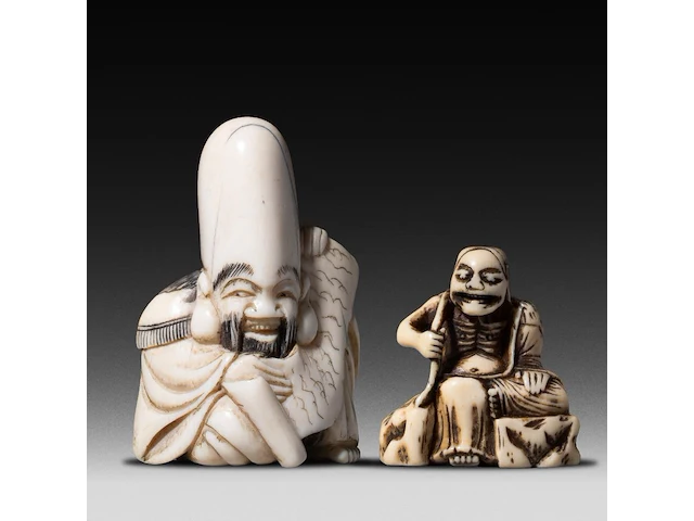 A japanese ivory netsuke of a rakan, edo period (probably 18thc), h 4,5 cm - 26g added; a japanese ivory netsuke of jurojin, meiji/taisho period (early 20thc), h 5,5 cm - 34g (+) - afbeelding 1 van  7