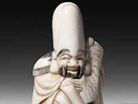 A japanese ivory netsuke of a rakan, edo period (probably 18thc), h 4,5 cm - 26g added; a japanese ivory netsuke of jurojin, meiji/taisho period (early 20thc), h 5,5 cm - 34g (+) - afbeelding 2 van  7