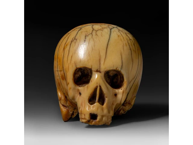 A japanese ivory netsuke of a skull, edo period (18th/19thc), h 3,7 cm - w 4,5 cm - d 3,4 cm - 51g (+) - afbeelding 1 van  7