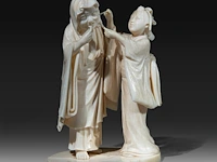A japanese ivory okimono of a lady cleaning a rakan's ear, signed, meiji period (1868-1912), h 12,5 cm (+)