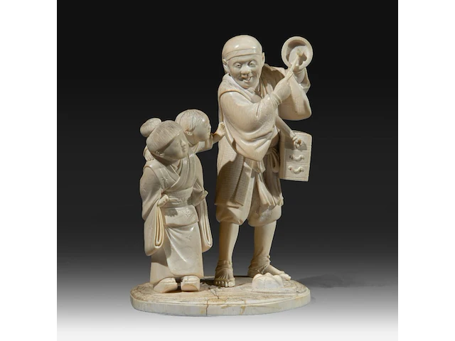 A japanese ivory okimono of a man with a basket and singing bowl, with a girl carrying a child to his side, signed, meiji period (1868-1912), h 18 cm - w 12 cm - d 10 cm (+) - afbeelding 1 van  10
