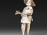 A japanese ivory okimono of a merchant selling seafood, signed, meiji period (1868-1912), h 23 cm - 387g (+)