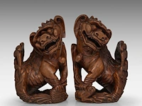 A pair of chinese carved rosewood models of buddhist lions, late qing, total h 25,5 cm