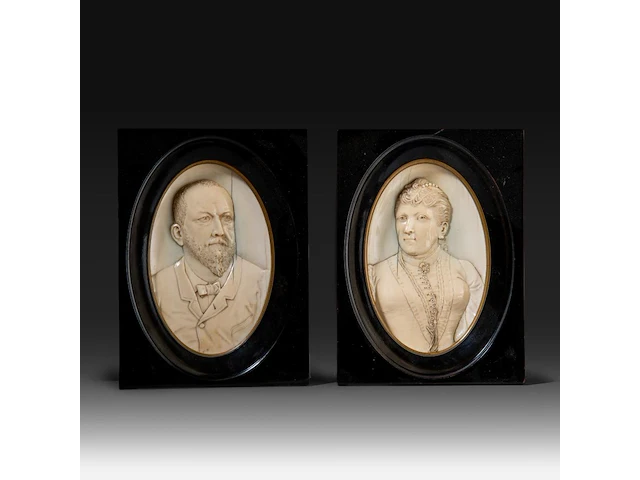 A pair of ivory oval relief sculpted portraits of a couple, late 19thc, ivory 21x12,5 cm - frame 23x17 cm - total weight (together) 1250g (+) - afbeelding 1 van  4