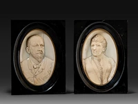 A pair of ivory oval relief sculpted portraits of a couple, late 19thc, ivory 21x12,5 cm - frame 23x17 cm - total weight (together) 1250g (+)