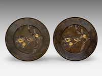 A pair of japanese bronze decorative plates with gold and silver relief decor of a bird among flowering branches, meiji period (1868-1912), ø 30 cm