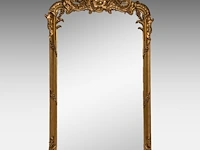 A richly gilt decorated rococo style wall mirror 190 x 116 cm. (74.79 x 45.67 in.)