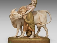 A royal dux group of a young woman feeding her cow 43 x 40 cm. (16.92 x 15 3/4 in.)