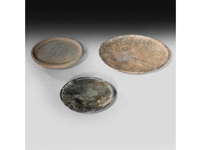 A set of three mesopotamian well-patinated schist and stone plates, syria, circa 2000-1000 bce (+) - afbeelding 1 van  6