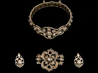 A silver bracelet, a brooch and a pair of earrings, set with diamonds, total weight: ca 55,7 g
