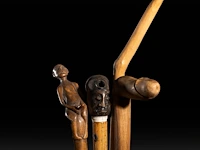 A various collection of carved wooden folk walking sticks with phallic handles