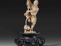A very fine japanese ivory okimono of a man fighting a tiny dragon, meiji period (1868-1912); total h 18 cm - ivory h 12,5 cm - total weight 237g (+)