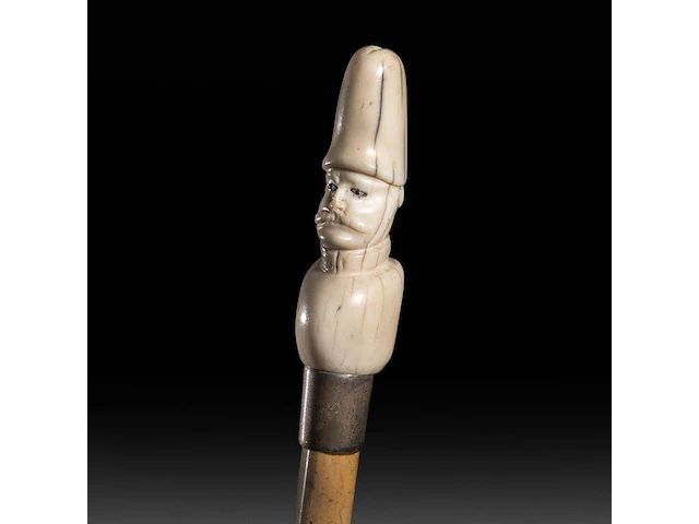 A walking stick with ivory handle depicting a soldier's bust wearing an oversized helmet in the shape of a phallus, german, 19thc, total h 95 cm - ivory h 10 cm - ivory w 2,8 cm - total weight 177g (+) - afbeelding 1 van  5