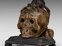 An 18thc polychrome wood memento mori skull with a snake and tree roots 16 cm. (6.29 in.)