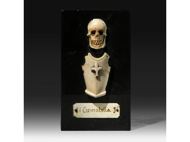 An ivory memento mori sculpture of a skull and armour with a nameplate '21 cromatella j.', 19thc, fixed on a stone plaque, h 14 cm - w 8 cm (+) - afbeelding 1 van  3