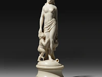 An ivory sculpture of venus carrying a jug, accompanied by cupid, french, 19thc, h 22 cm (+)