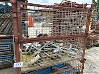 Draadstalen kooi inhoudende diverse metalen stelvoeten met wielen.
