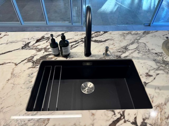 Exclusieve showroomkeuken met luxe keramisch monobloc-eiland, hoogwaardige neff-toestellen en novy dampkap - afbeelding 15 van  23