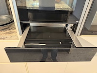Exclusieve showroomkeuken met luxe keramisch monobloc-eiland, hoogwaardige neff-toestellen en novy dampkap - afbeelding 19 van  23